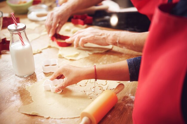 Cerca de la mano humana cortando cookies