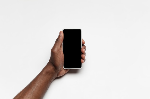 Cerca de la mano humana con gadget con pantalla en blanco negro