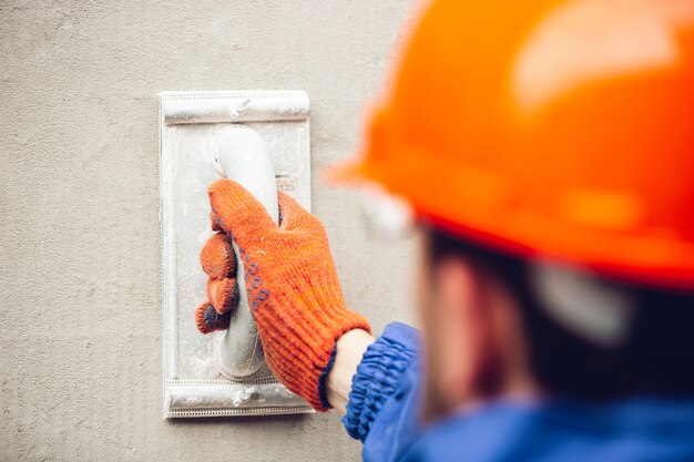 Cerca de la mano del reparador, constructor profesional trabajando en interiores, reparando