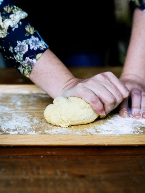 Cerca de las manos amasando la masa para pastelería