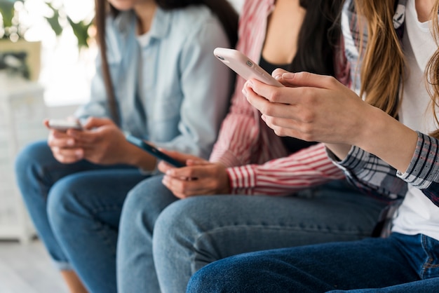 Cerca de las manos de las damas con teléfonos