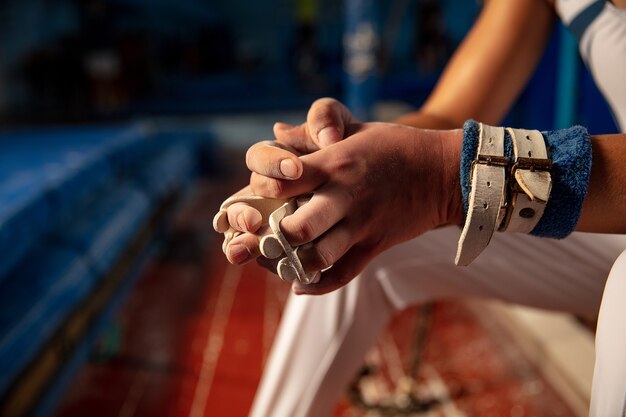 Foto gratuita cerca de las manos del entrenamiento de gimnasta en gimnasio, flexible y activo.