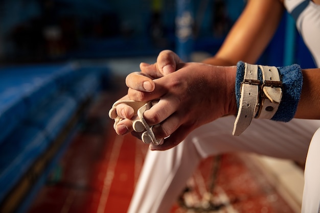 Cerca de las manos del entrenamiento de gimnasta en gimnasio, flexible y activo.