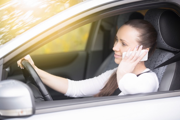 Cerca de las manos femeninas se sostienen en el volante