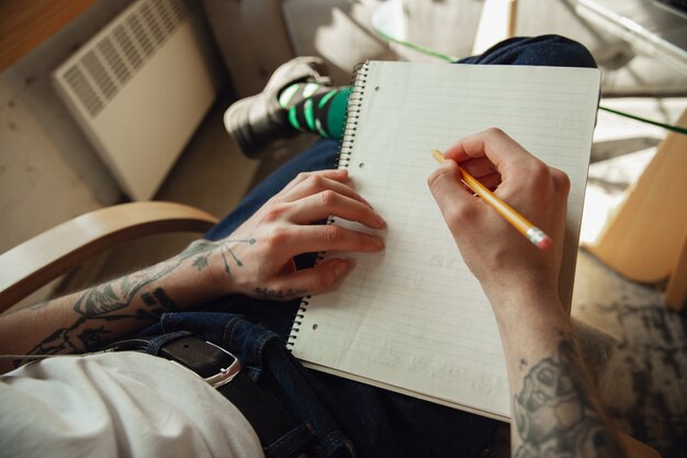 Cerca de manos masculinas escribiendo en un papel vacío, educación y concepto de negocio