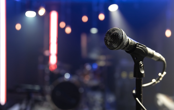 Foto gratuito cerca de un micrófono en un escenario de conciertos con una hermosa iluminación.