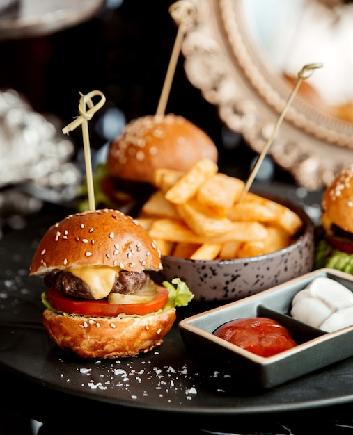 Cerca de mini hamburguesa de ternera servida con salsa de tomate y mayonesa