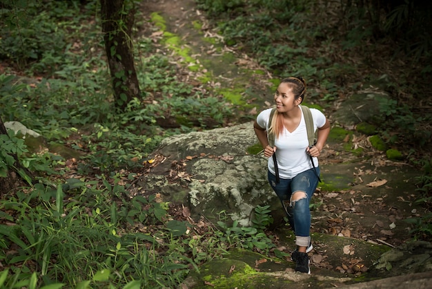 Cerca de mochileros jóvenes caminando por el bosque feliz con la naturaleza. Concepto de viaje