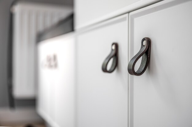 Cerca de muebles blancos minimalistas con asas negras detalles del armario de cocina
