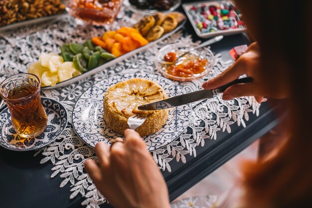 Cerca de mujer cortando pastel de pera en porciones servido para el té