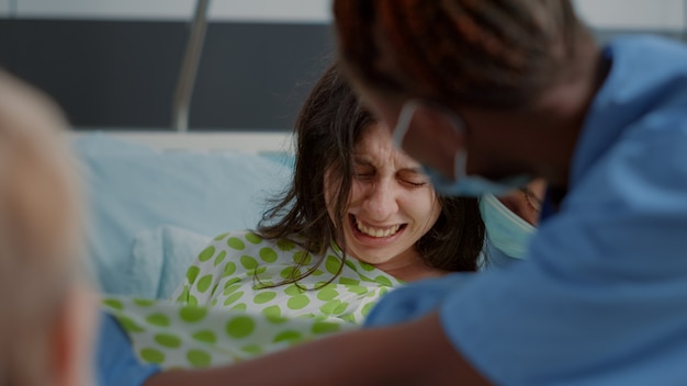 Foto gratuita cerca de la mujer en el doloroso trabajo de parto dando a luz a un niño