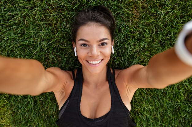 Cerca de una mujer feliz fitness en auriculares