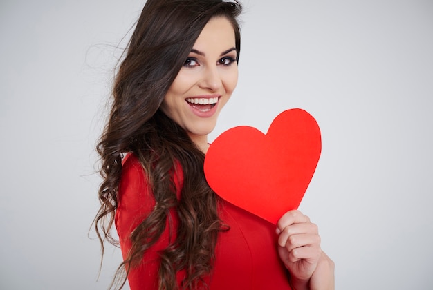 Cerca de mujer sosteniendo corazón de papel rojo