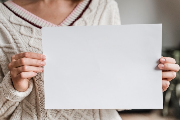 Cerca de una mujer sosteniendo un papel en blanco