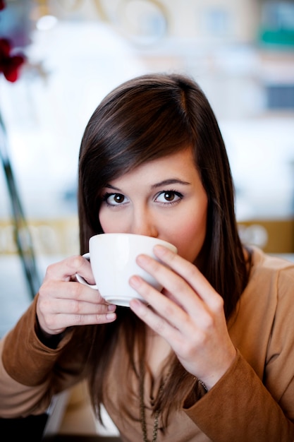 Cerca de mujer tomando café