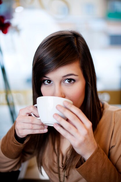 Cerca de mujer tomando café