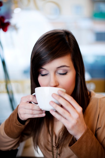 Cerca de mujer tomando café