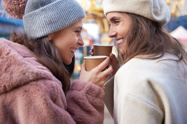 Cerca de mujeres bebiendo vino caliente al aire libre