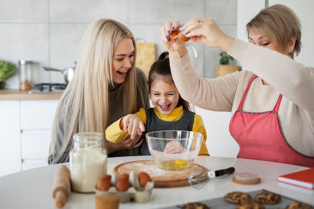 Cerca de niña cocinando con su madre y su abuela