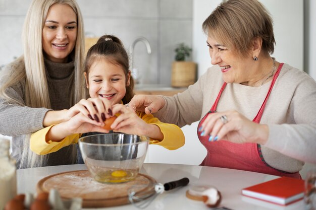 Cerca de niña cocinando con su madre y su abuela