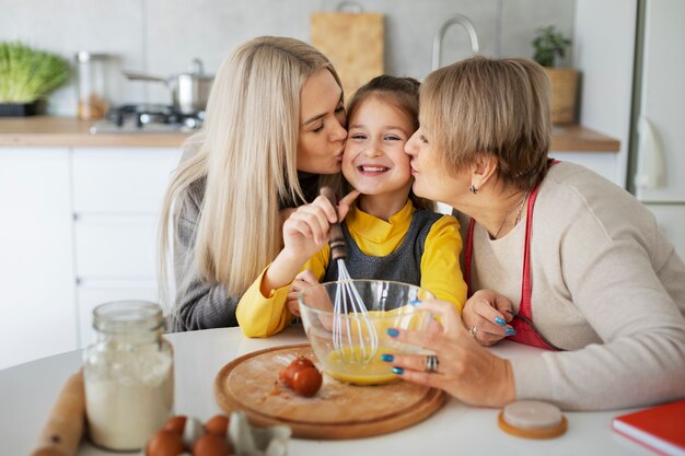 Cerca de niña cocinando con su madre y su abuela