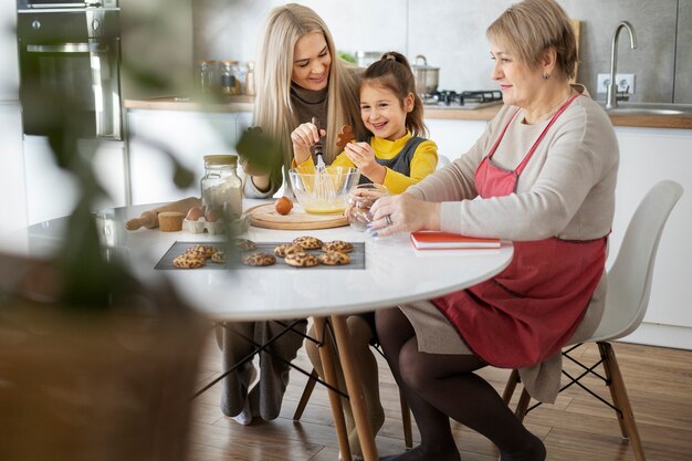 Cerca de niña cocinando con su madre y su abuela