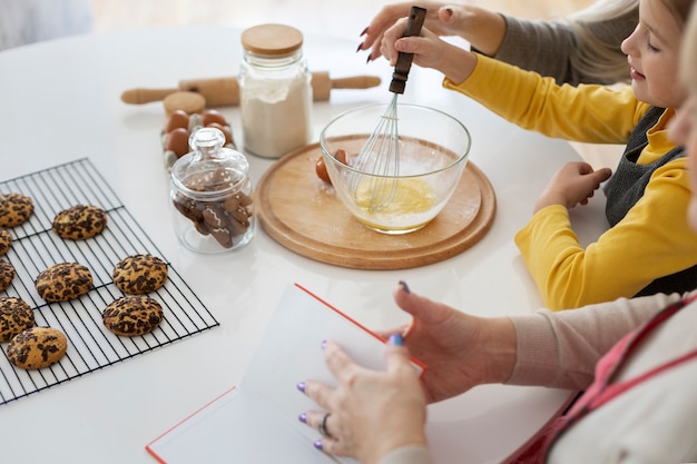 Cerca de niña cocinando con su madre y su abuela