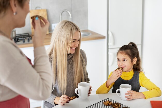 Cerca de niña cocinando con su madre y su abuela