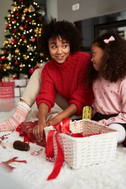 Cerca de niñas empacando regalos para Navidad