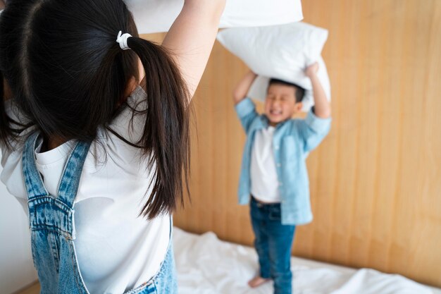 Cerca de niños que tienen pelea de almohadas