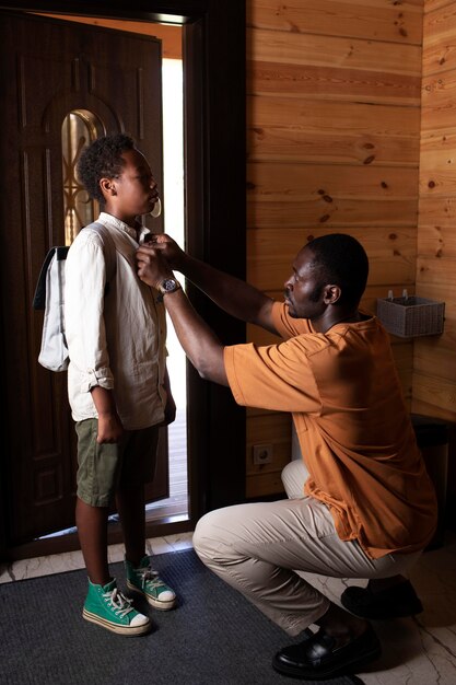 De cerca a los padres preparando a su hijo para la escuela