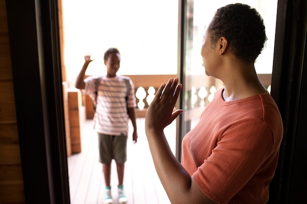 Foto gratuita de cerca a los padres preparando a su hijo para la escuela