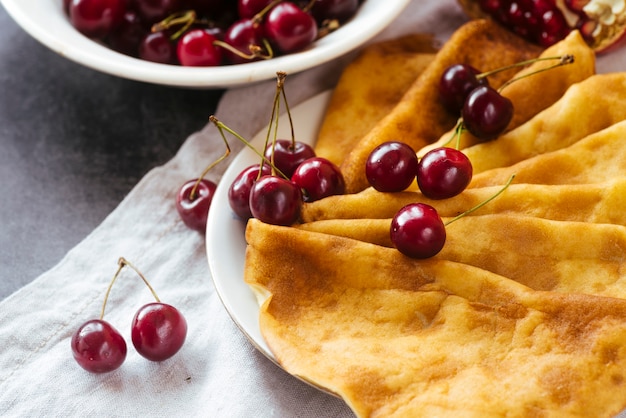 Cerca de panqueques y desayuno de cerezas.