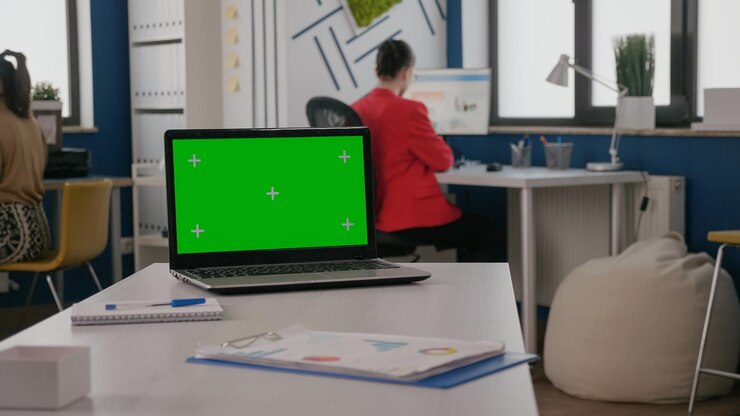 Foto gratuito cerca de la pantalla verde en la computadora portátil en la oficina de negocios. computadora con fondo de clave de croma y plantilla de maqueta aislada en el escritorio vacío. espacio de copia digital chroma-key en pantalla.