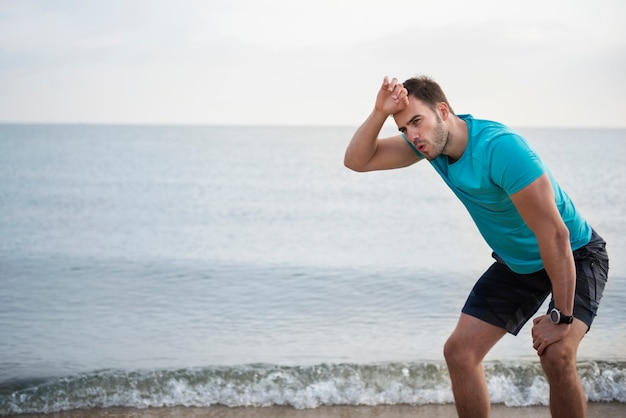 Cerca de la persona joven en forma de jogging por el mar