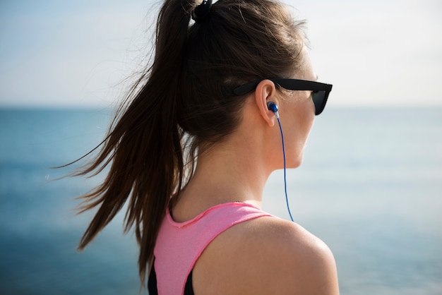 Cerca de la persona joven en forma de jogging por el mar