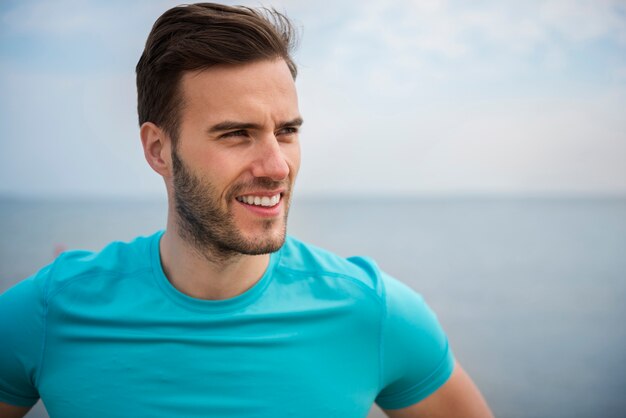 Cerca de la persona joven en forma de jogging por el mar