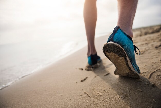 Cerca de la persona joven en forma de jogging por el mar