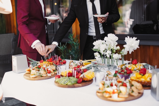 Foto gratuita cerca de personas sirviéndose las frutas en el buffet del restaurante