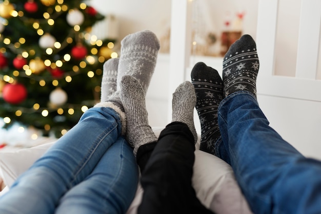 Cerca de las piernas de la familia en calcetines calientes