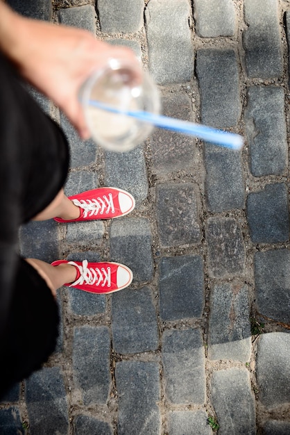 Cerca de las piernas de la niña en keds de pie en la calle