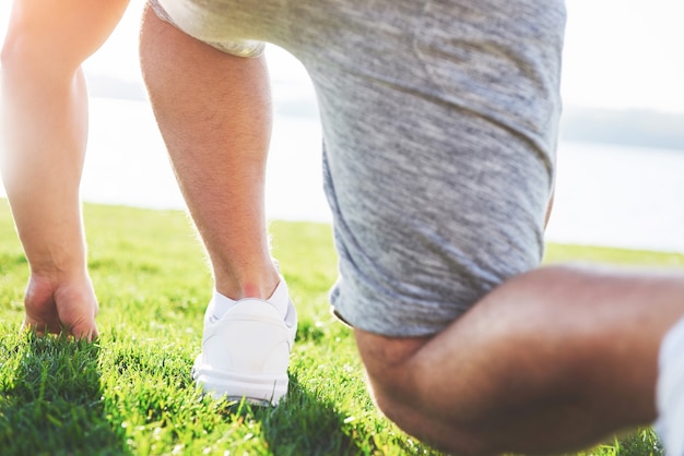 Foto gratuita cerca de los pies de un hombre corriendo en la hierba.