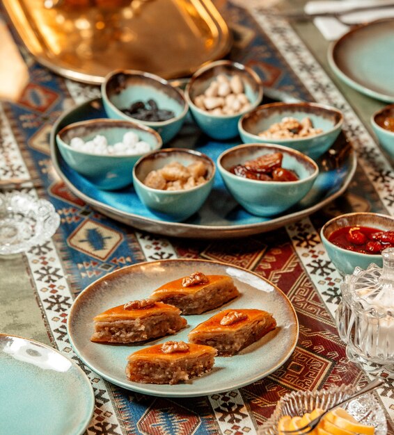 Cerca de la placa de pakhlava junto al plato de turrones, nueces y dulces