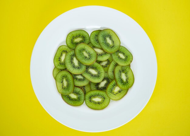 Cerca de un plato de rodajas de fruta kiwi verde