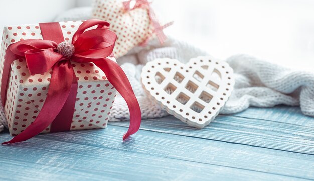 Cerca de regalo de San Valentín y corazón decorativo sobre una superficie de madera. El concepto de la fiesta de todos los amantes.
