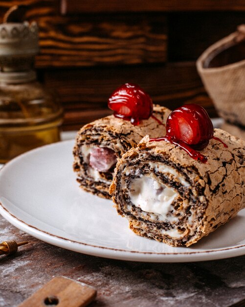 Cerca del rollo de pastel cubierto con fresa en plato blanco