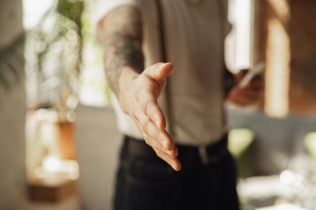 Cerca del saludo de la mano masculina, dando la bienvenida a alguien.