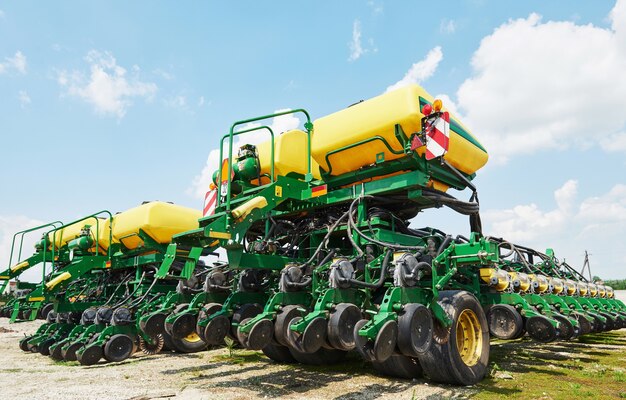 Cerca de la sembradora adjunta al tractor en el campo.