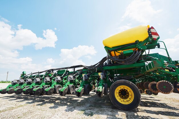 Cerca de la sembradora adjunta al tractor en el campo.