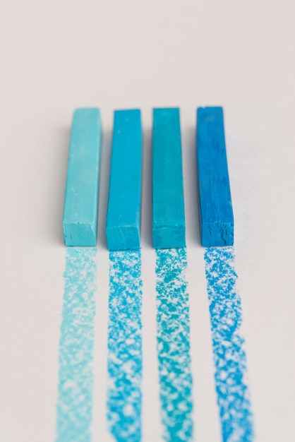 Cerca de tizas de crayón pastel de color azul sobre su propia línea de trazado